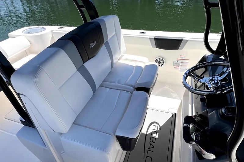 Slide: The Image of 2021 Robalo R272 Center Console boat interior with white seating and steering wheel. - 16