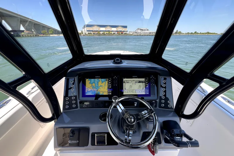 Slide: The Image of 2021 Robalo R272 Center Console helm with advanced navigation displays on open water. - 17