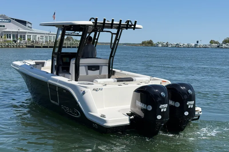 Slide: The Image of 2021 Robalo R272 Center Console boat with twin Yamaha 250 V6 engines on water. - 2