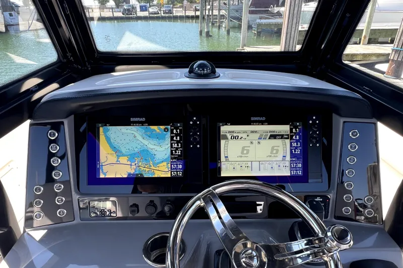 Slide: The Image of Helm of 2021 Robalo R272 Center Console with dual Simrad displays and steering wheel. - 20