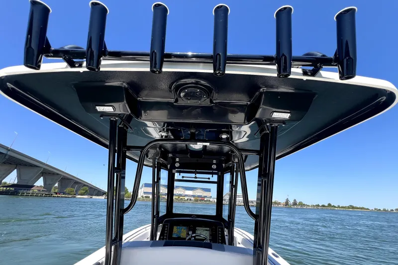 Slide: The Image of 2021 Robalo R272 Center Console boat with T-top and rod holders on the water. - 22