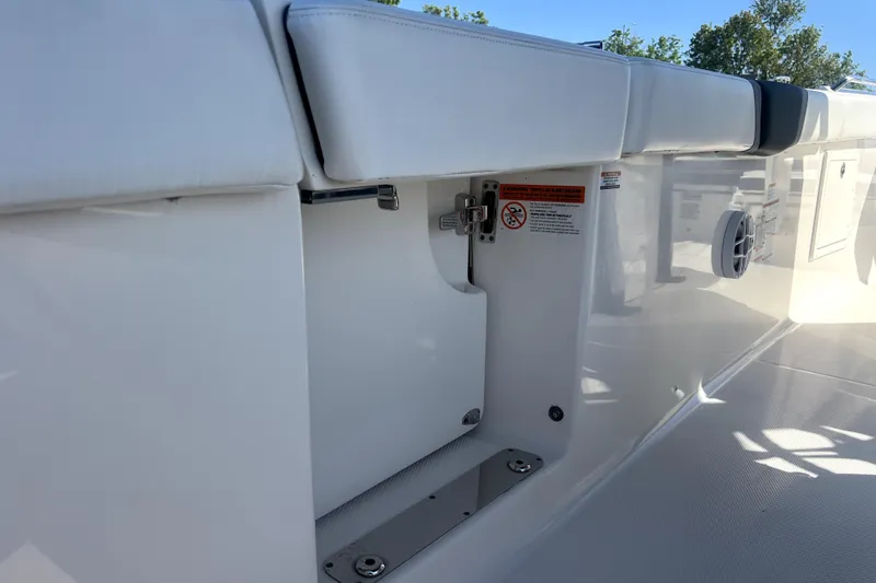Slide: The Image of 2021 Robalo R272 Center Console boat interior with cushioned seating and storage compartment. - 26