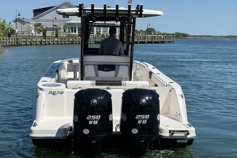 Slide: The Image of 2021 Robalo R272 Center Console boat with dual 250 V6 engines on water. - 3