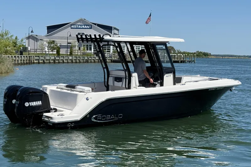 Slide: The Image of 2021 Robalo R272 Center Console boat on water near a restaurant, featuring Yamaha engines. - 4