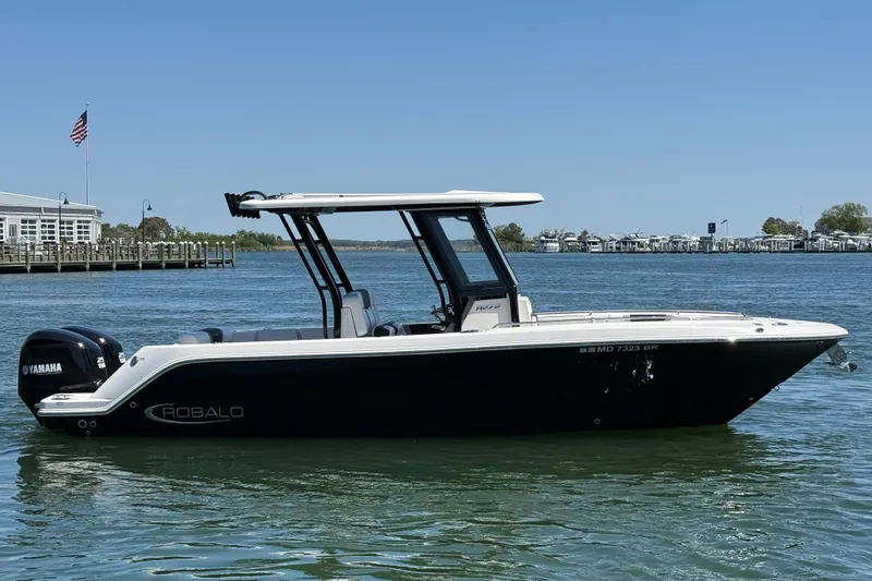 Slide: The Image of 2021 Robalo R272 Center Console boat on calm water, featuring Yamaha engines. - 6