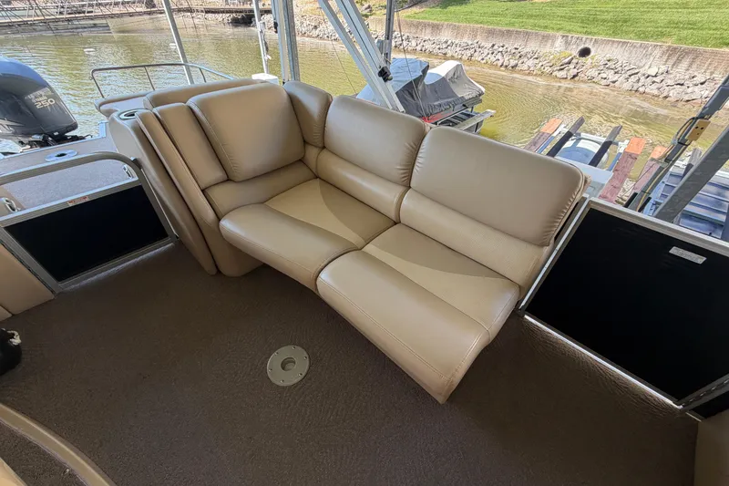 Slide: The Image of Luxurious seating on a 2011 Bennington 2575QCW OB pontoon boat, docked by the water. - 18