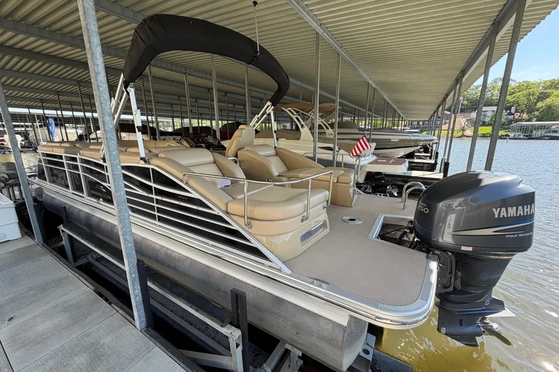 Slide: The Image of 2011 Bennington 2575QCW OB pontoon boat docked with Yamaha outboard motor. - 2