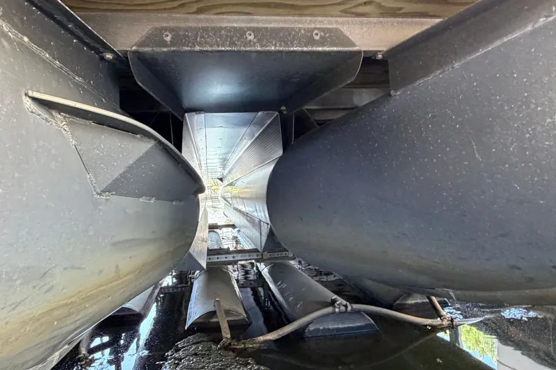 Slide: The Image of Underneath view of a 2011 Bennington 2575QCW OB pontoon boat, showcasing pontoons and structure. - 29