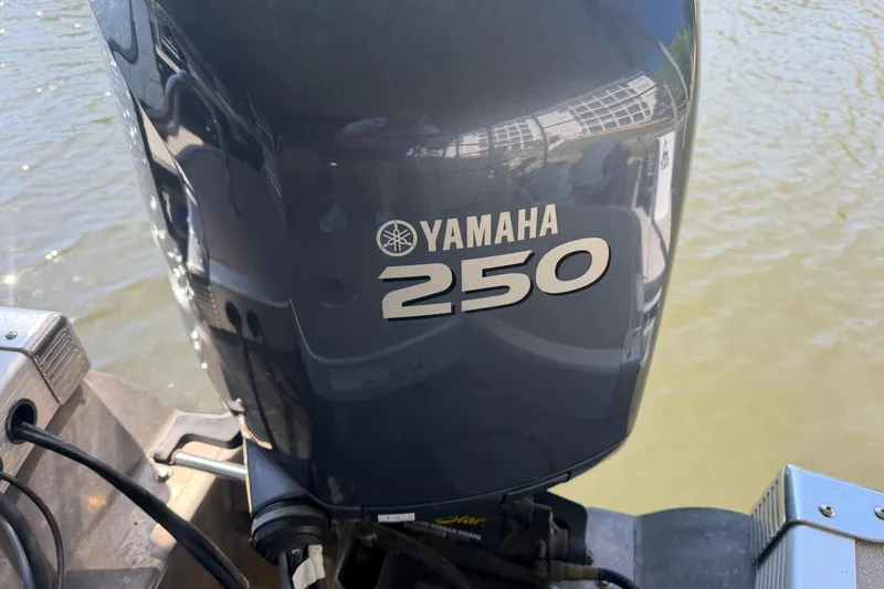 Slide: The Image of Yamaha 250 outboard motor on 2011 Bennington 2575QCW OB boat, near water. - 5