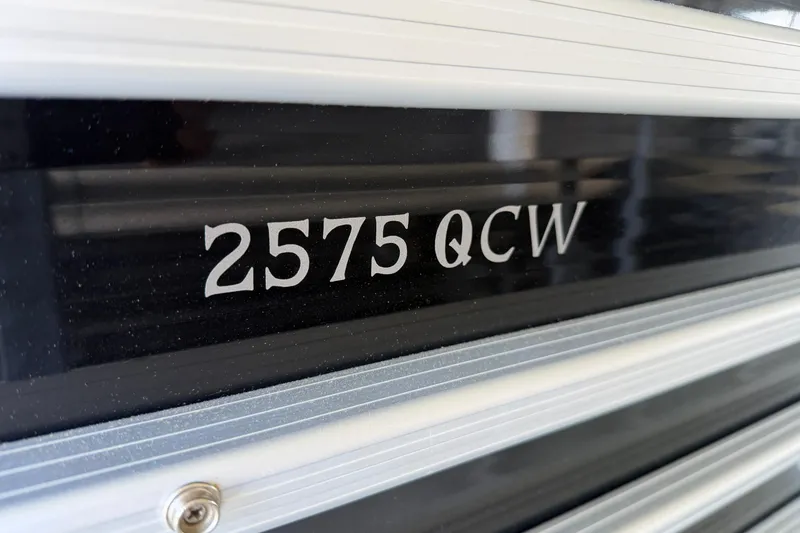 Slide: The Image of Close-up of 2011 Bennington 2575QCW OB model nameplate on black surface. - 9
