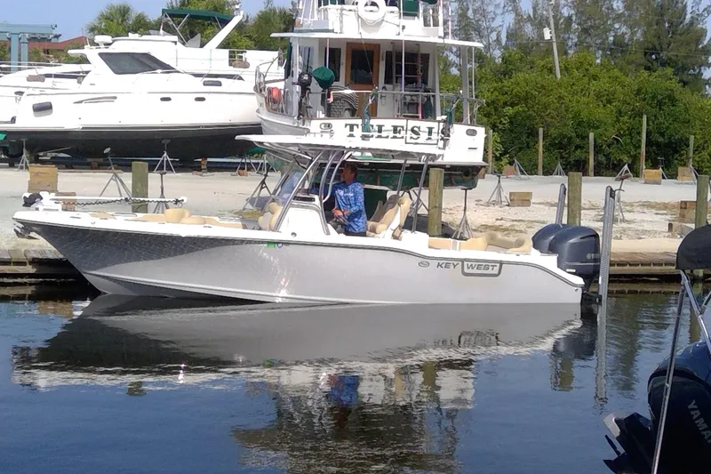 The Image of 2020 Key West 263 FS boat docked at marina with lush greenery in background. - 0