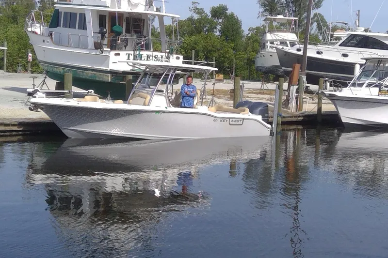 Slide: The Image of 2020 Key West 263 FS boat docked at marina with person onboard. - 25