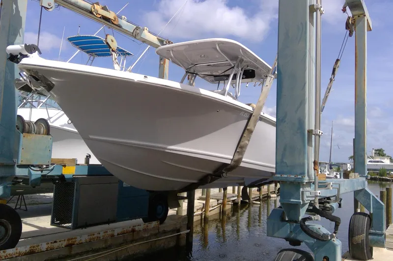 Slide: The Image of 2020 Key West 263 FS boat on lift at marina, clear sky background. - 35