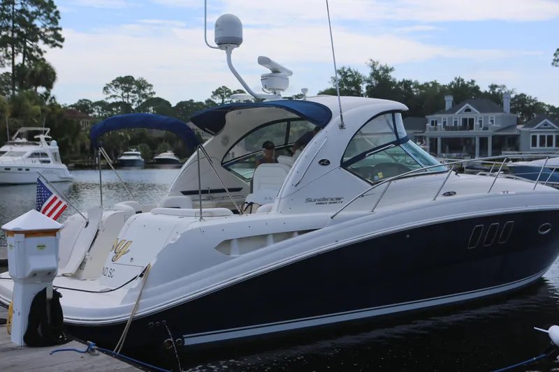 Slide: The Image of 2010 Sea Ray 390 Sundancer yacht docked in a scenic marina setting. - 1