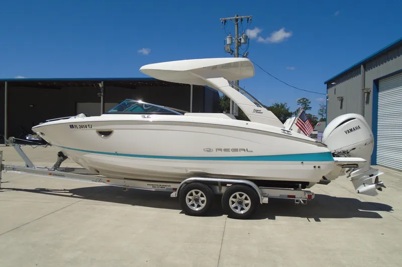 The Image of 2022 Regal LX6 boat on trailer, featuring Yamaha engine, parked outdoors. - 0