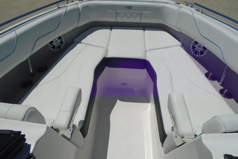 Slide: The Image of 2022 Regal LX6 boat interior with white cushioned seating and speaker system. - 14
