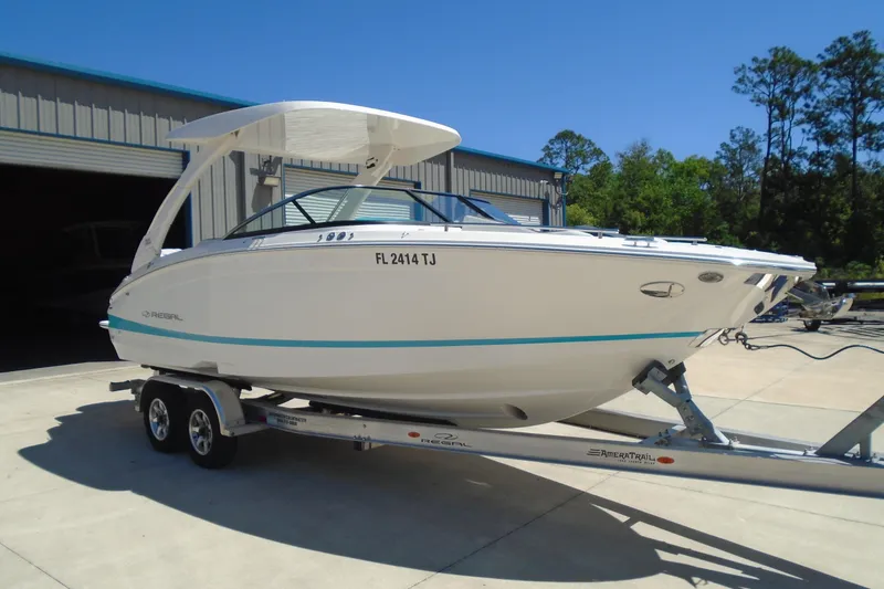 Slide: The Image of 2022 Regal LX6 boat on trailer, parked outside a warehouse. - 8