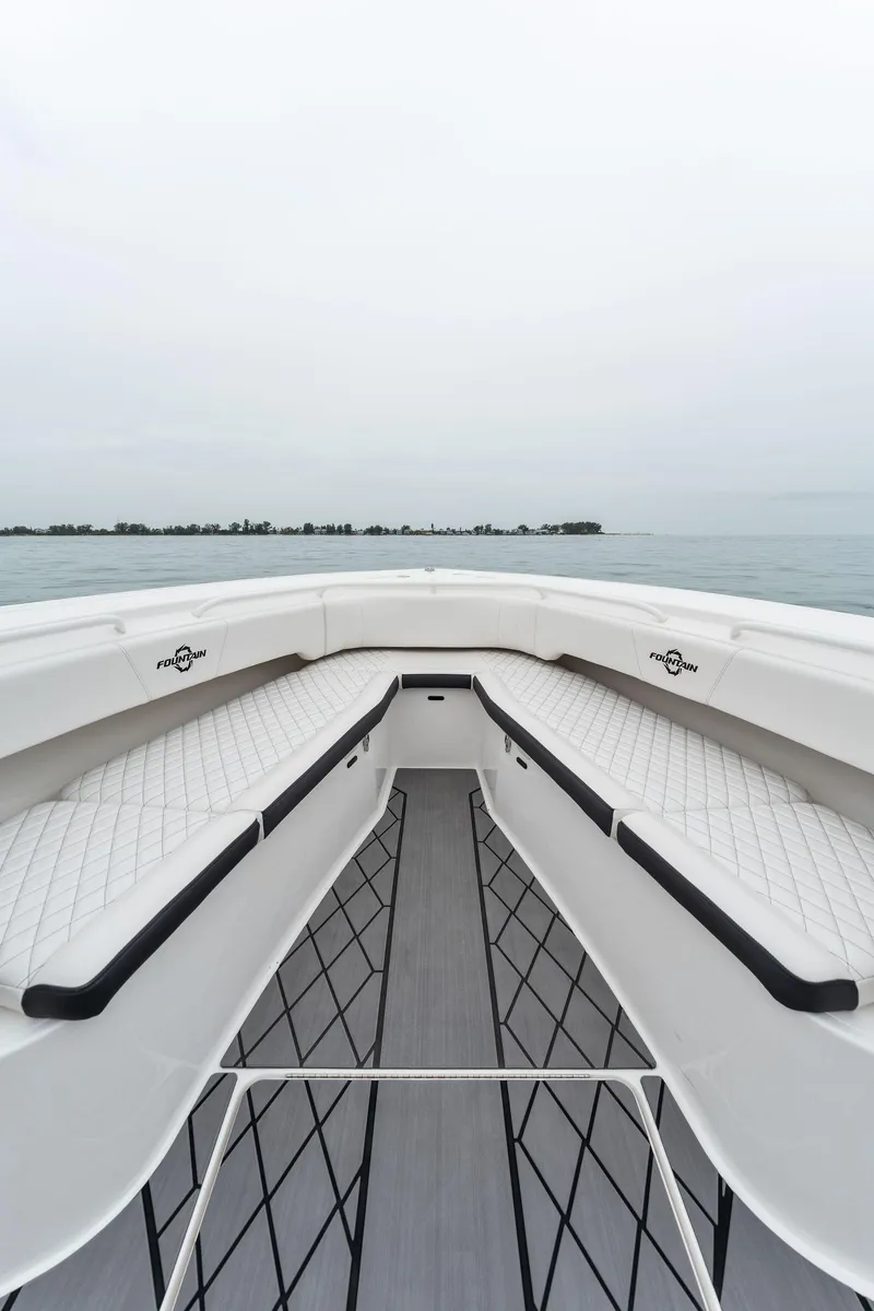 Slide: The Image of 2023 Fountain 38 CC boat interior with cushioned seating and ocean view. - 19
