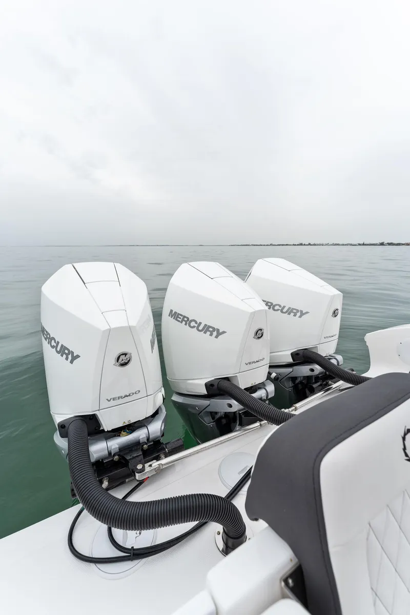 Slide: The Image of 2023 Fountain 38 CC with triple Mercury outboard engines on calm water. - 23