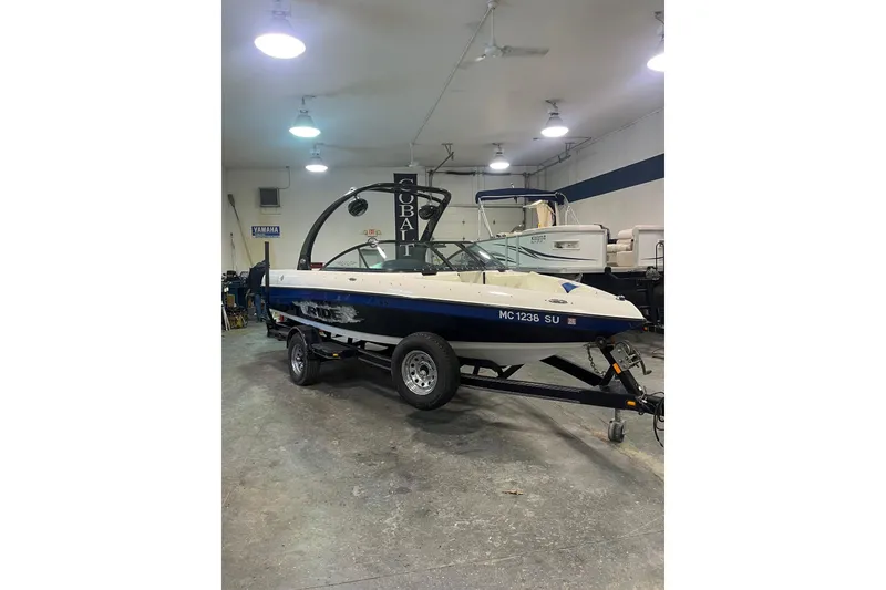 Slide: The Image of 2005 Malibu 21 Ride boat on trailer in indoor showroom. - 10