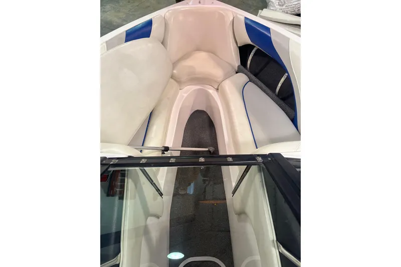 Slide: The Image of Interior view of a 2005 Malibu 21 Ride boat, featuring white and blue seating. - 5