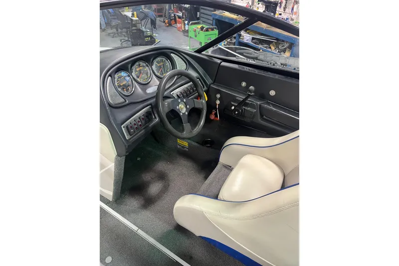 Slide: The Image of 2005 Malibu 21 Ride boat interior with steering wheel and dashboard gauges. - 6