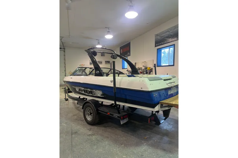 Slide: The Image of 2005 Malibu 21 Ride boat in a garage, mounted on a trailer. - 9
