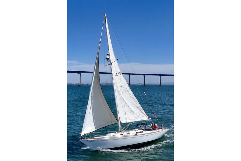 The Image of 1970 Morgan 42 MKI sailboat cruising under a clear blue sky near a bridge. - 1