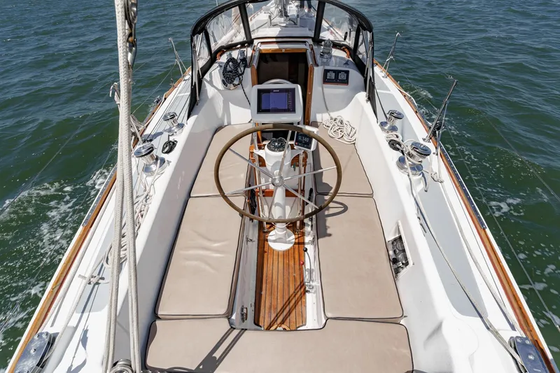 Slide: The Image of 1970 Morgan 42 MKI sailboat cockpit with wooden accents and steering wheel on open water. - 23