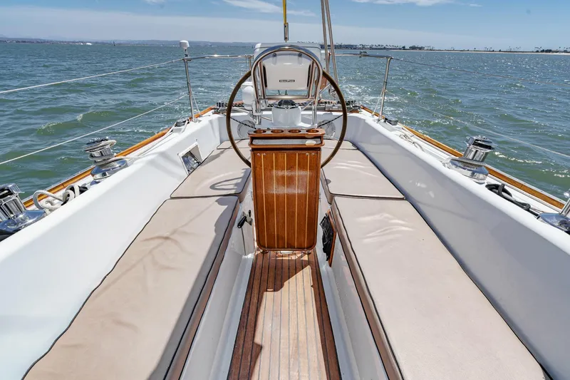 Slide: The Image of 1970 Morgan 42 MKI sailboat cockpit with wooden wheel, sailing on open water. - 29