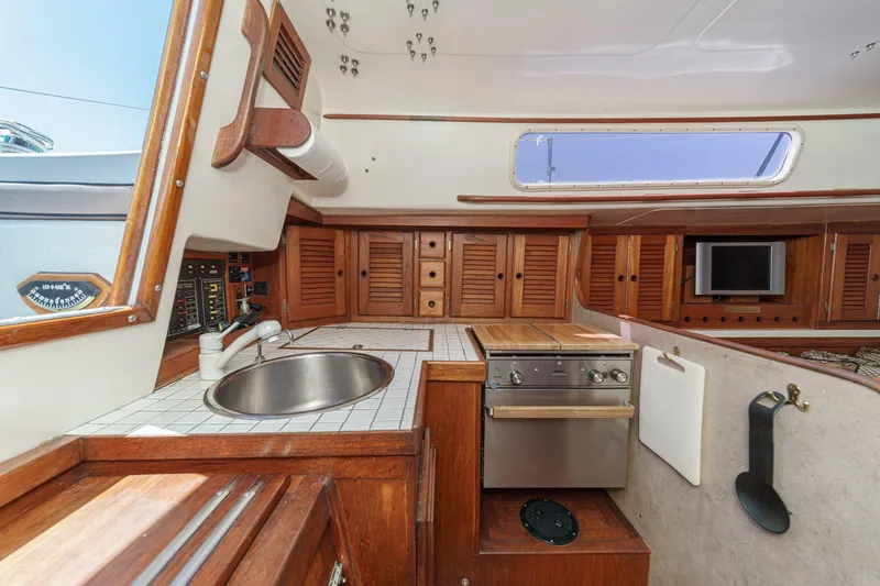 Slide: The Image of 1970 Morgan 42 MKI yacht interior with wooden cabinetry and compact kitchen area. - 38