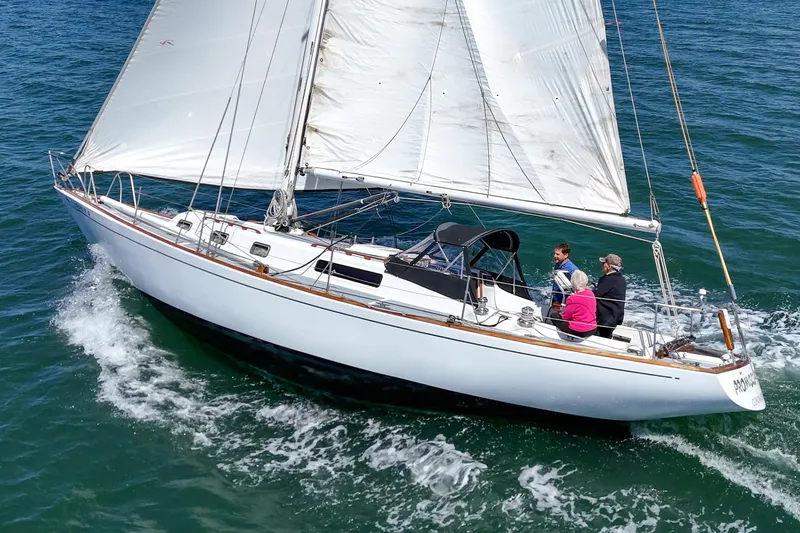 Slide: The Image of 1970 Morgan 42 MKI sailboat cruising on open water with three people onboard. - 4