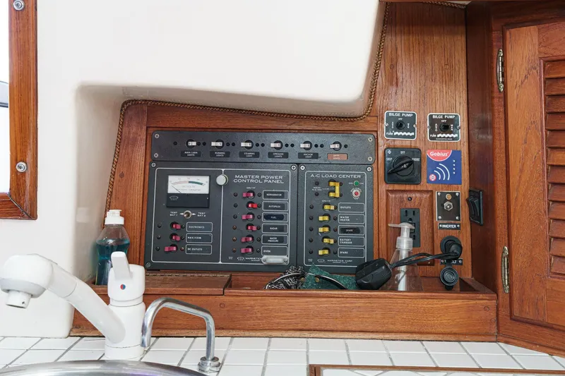 Slide: The Image of 1970 Morgan 42 MKI yacht control panel with switches and gauges in wooden cabinetry. - 43
