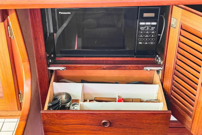 Slide: The Image of Wooden kitchen cabinet with Panasonic microwave and organized utensil drawer on a 1970 Morgan 42 MKI. - 53