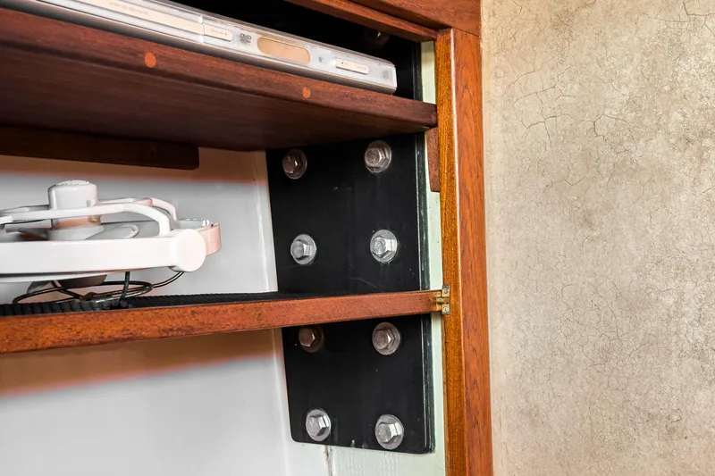 Slide: The Image of Interior view of a 1970 Morgan 42 MKI sailboat, showcasing wooden shelving and structural bolts. - 56