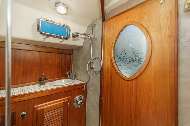 Slide: The Image of 1970 Morgan 42 MKI yacht bathroom with wooden cabinetry and nautical-themed door. - 68