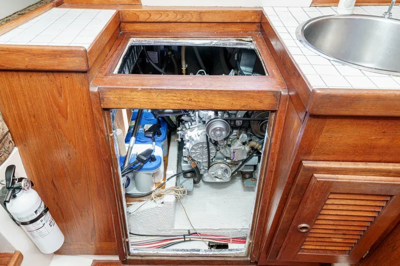 Slide: The Image of Engine compartment of a 1970 Morgan 42 MKI sailboat with wooden cabinetry and a sink. - 71