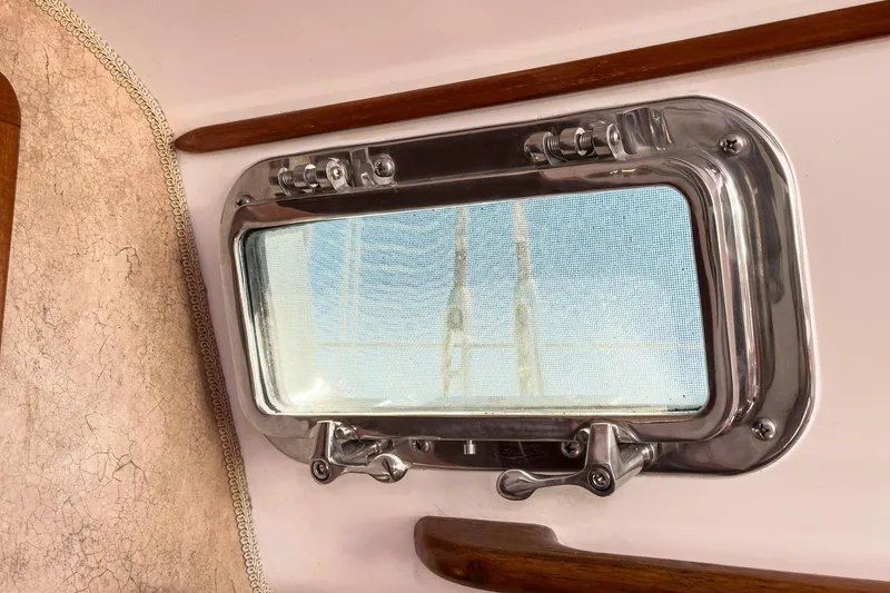 Slide: The Image of Port window of a 1970 Morgan 42 MKI sailboat, featuring polished metal frame. - 75