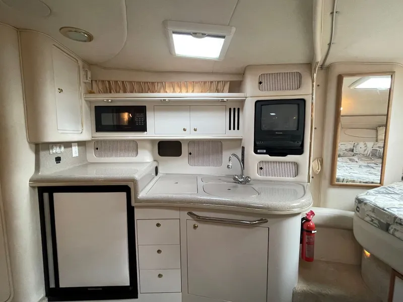 Slide: The Image of Interior of 1999 Sea Ray 340 Sundancer with kitchenette and TV. - 19