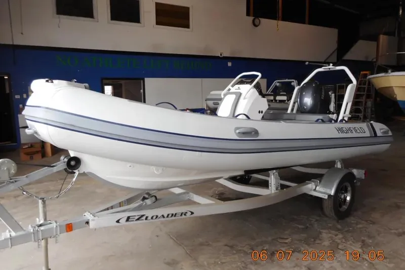 The Image of 2025 Highfield Classic 420 boat on EZ Loader trailer in a garage. - 5