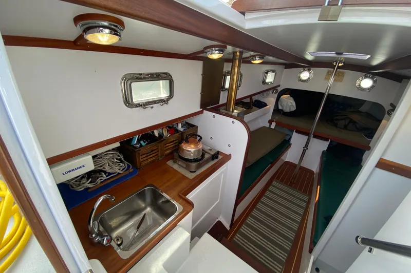 Slide: The Image of 2013 Devlin Onyx boat interior with kitchenette, sink, and seating area. - 14