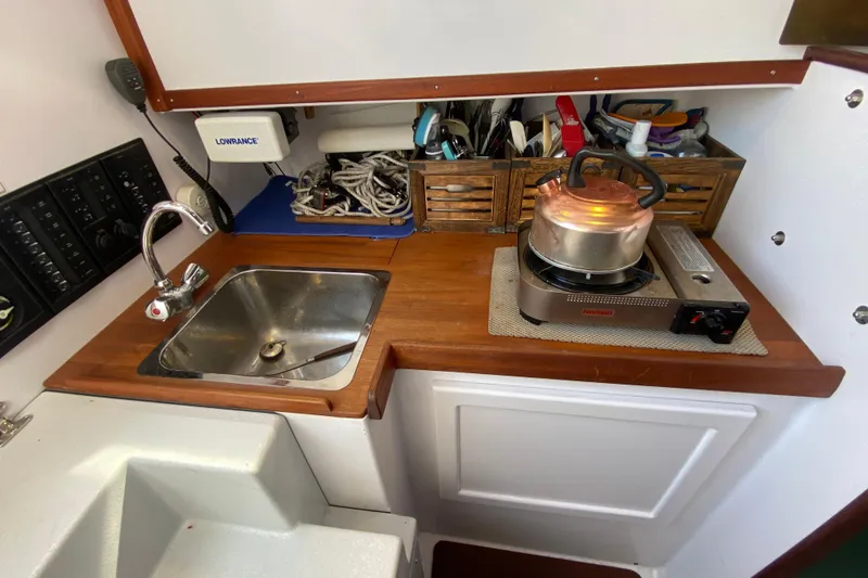 Slide: The Image of Compact boat kitchen with sink, stove, and storage on a 2013 Devlin Onyx model. - 15