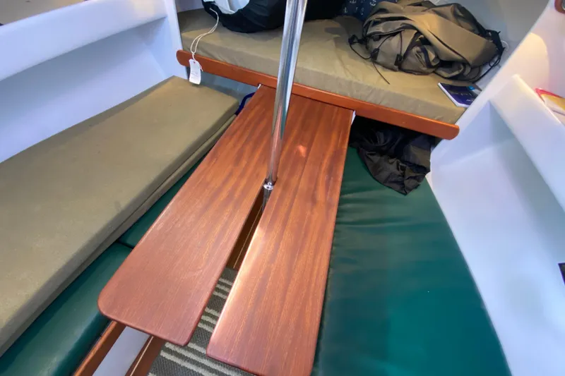 Slide: The Image of Interior of 2013 Devlin Onyx boat with wooden table and cushioned seating. - 19