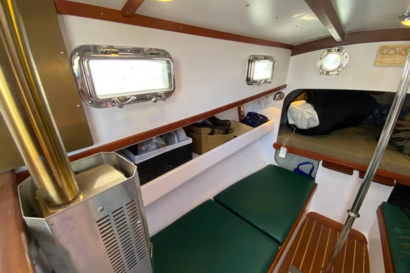 Slide: The Image of Cozy cabin interior of 2013 Devlin Onyx boat with green seating and porthole windows. - 20
