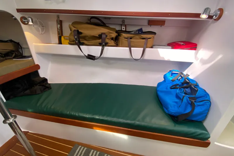 Slide: The Image of Interior of 2013 Devlin Onyx boat with green cushioned bench and storage shelves. - 23