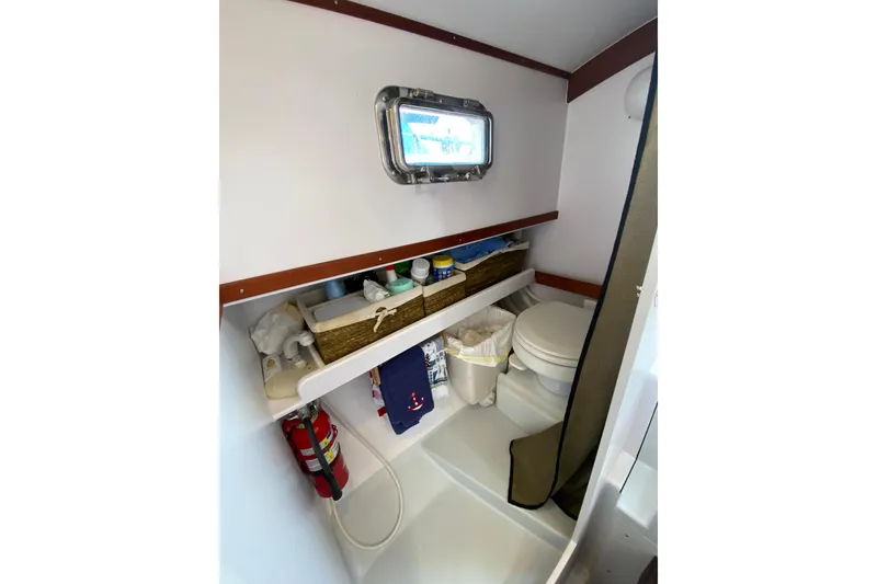 Slide: The Image of Compact bathroom in 2013 Devlin Onyx boat with toilet, storage, and porthole window. - 26