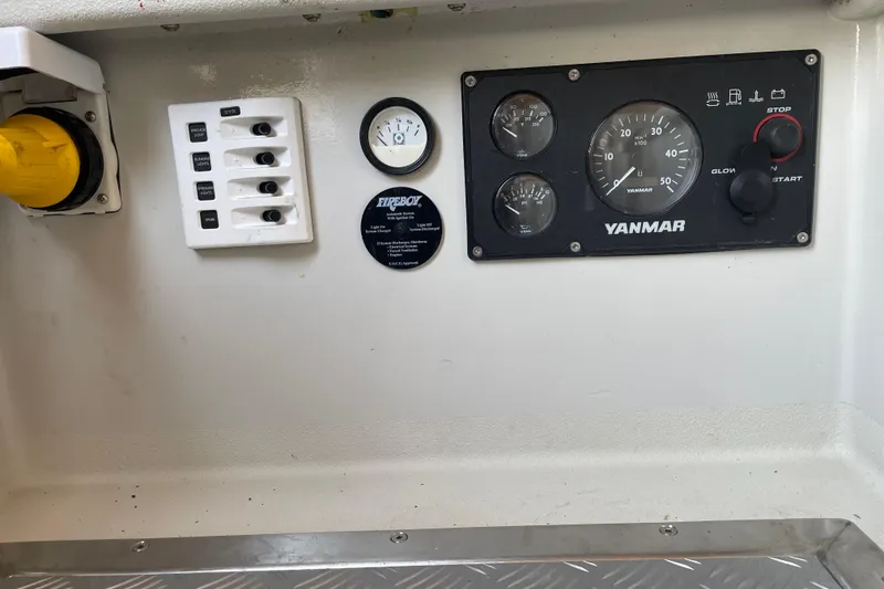 Slide: The Image of Control panel of a 2013 Devlin Onyx boat featuring Yanmar gauges and switches. - 33