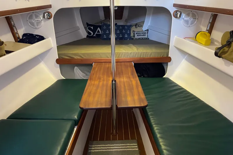 Slide: The Image of Cozy interior of 2013 Devlin Onyx sailboat with green seating and wooden table. - 34