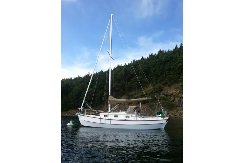 Slide: The Image of Sailboat Devlin Onyx 2013 anchored near forested shoreline under blue sky. - 36