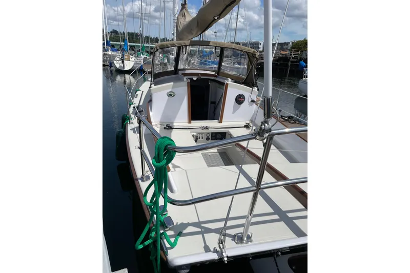Slide: The Image of 2013 Devlin Onyx sailboat docked at marina, featuring green rope and sleek design. - 38